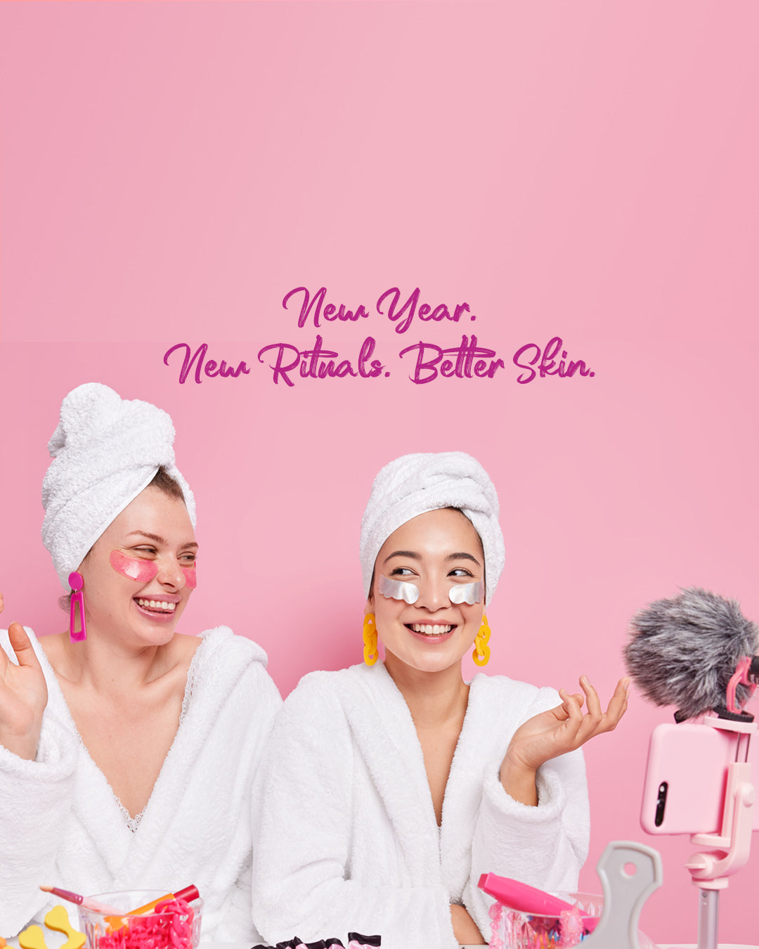 Two women in bathrobes with towel wraps on heads, smiling at a camera with text 'New Year. New Rituals.